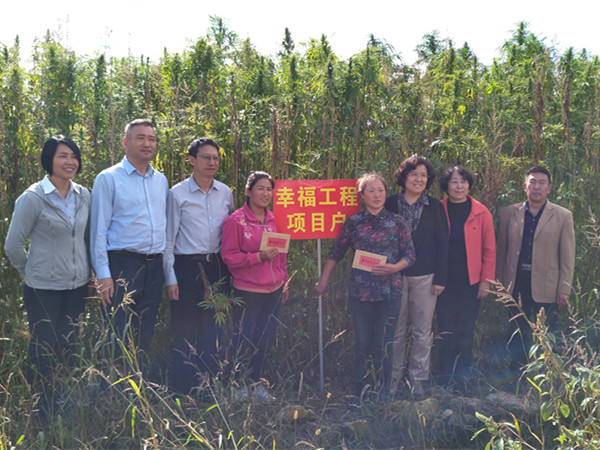 郝林娜理事长一行与受助母亲高云翠、徐红在自家汉麻种植地前合影留念_副本.jpg